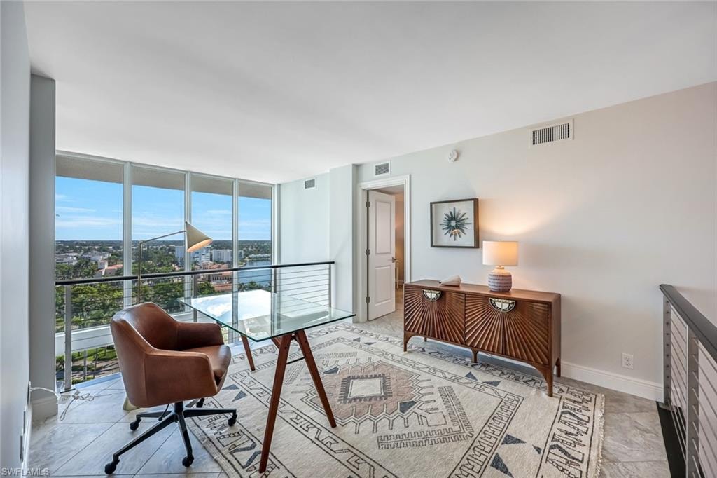 Home office featuring floor to ceiling windows and baseboards