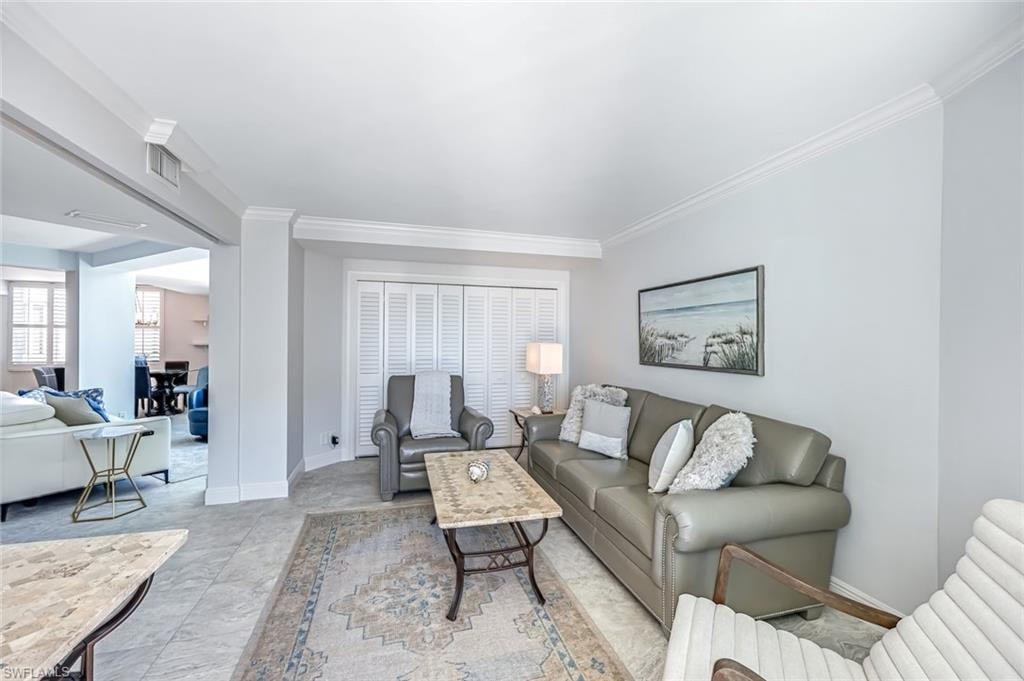 Living area with ornamental molding and baseboards