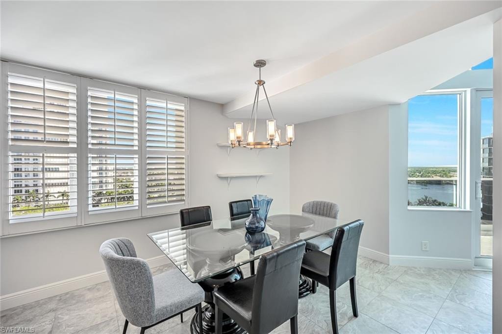 Dining area featuring a chandelier and baseboards
