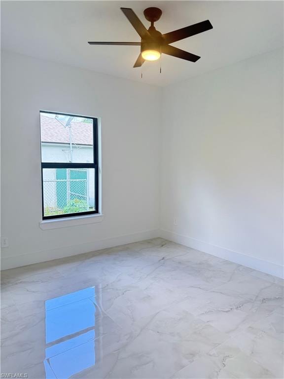 Spare room with a ceiling fan and light marble finish flooring