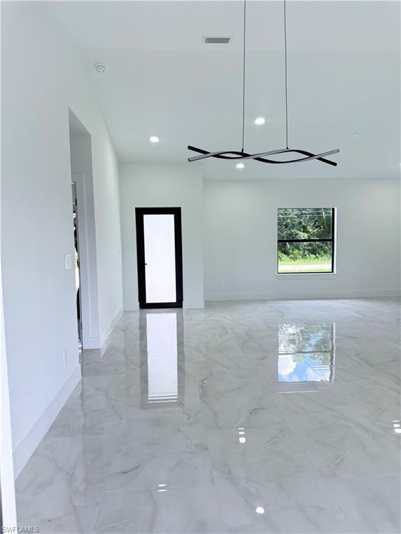 Spare room with light marble finish floors and recessed lighting