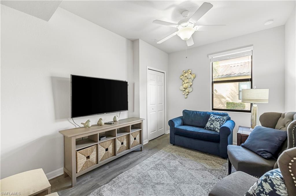 Den/ sitting room with single pull-out sleeper couch, wood pattern tile floors and a ceiling fan