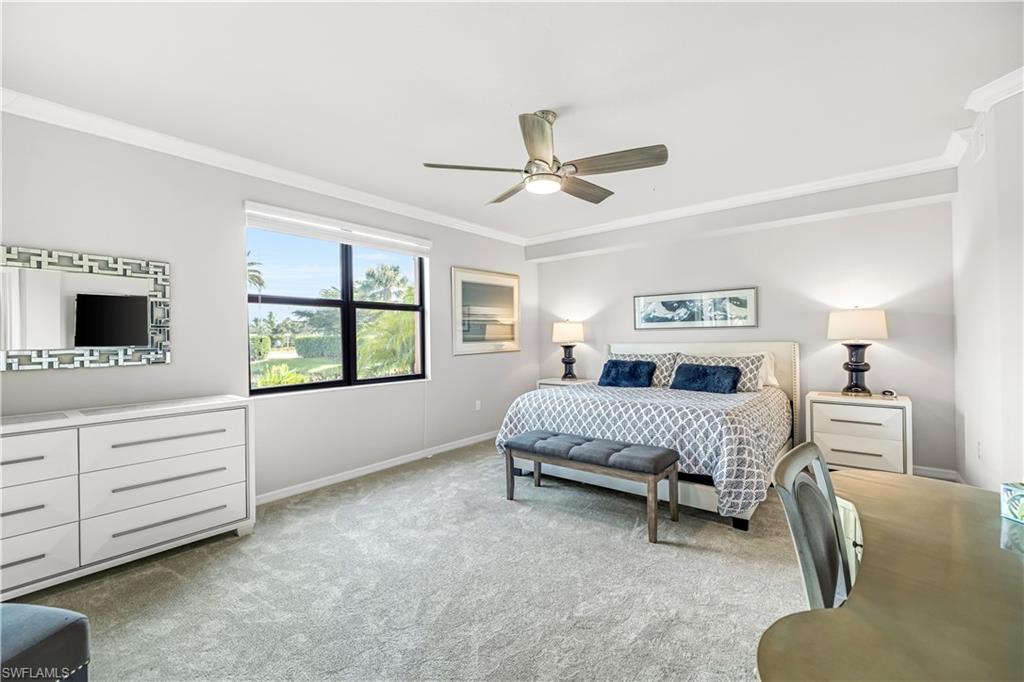 Bedroom with ornamental molding, light colored carpet, and a ceiling fan