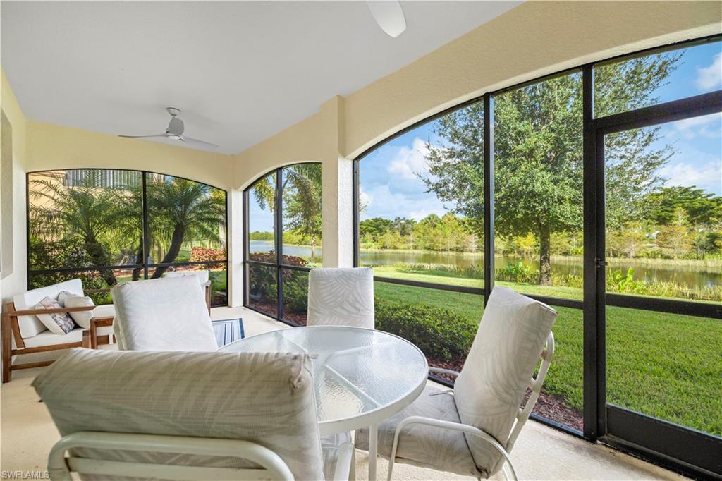 Sunroom / solarium featuring a ceiling fan, a water view, and outdoor dining area