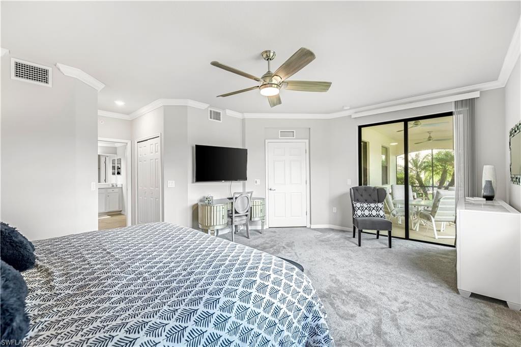 Carpeted bedroom with ornamental molding, access to outside, ceiling fan, and 2 walk-in closets
