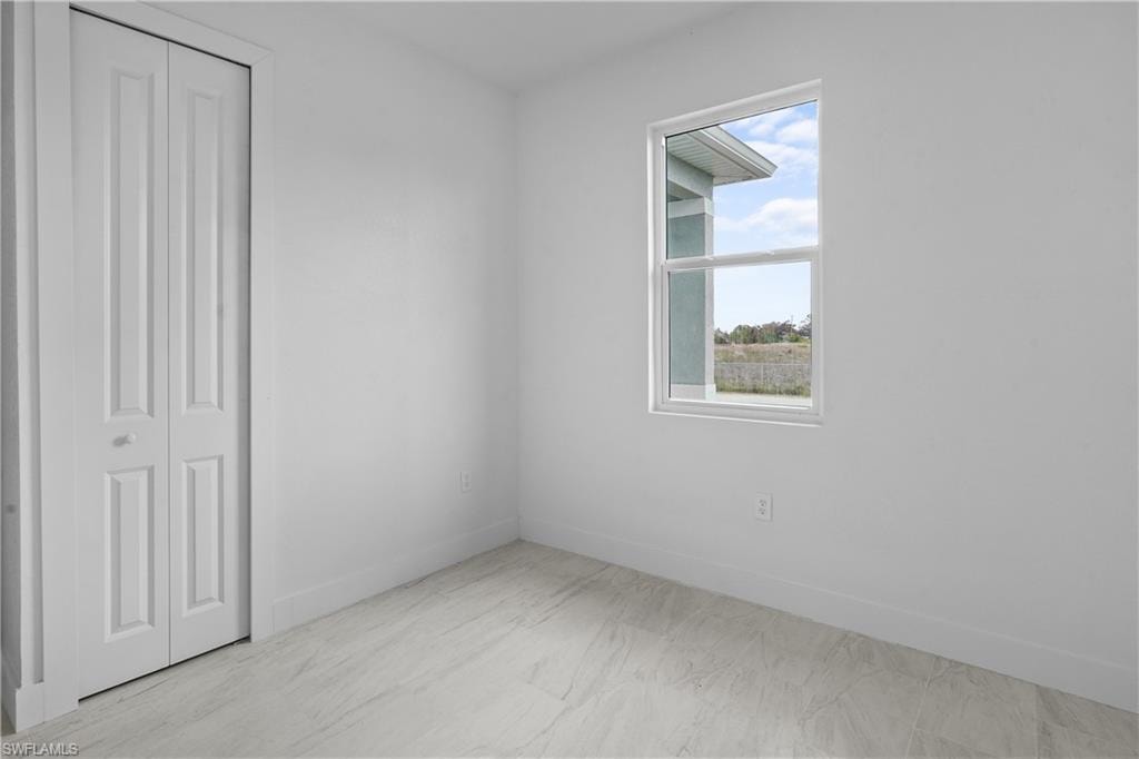 Unfurnished bedroom with a closet and baseboards