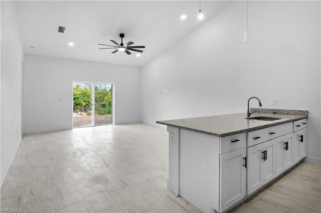 Unfurnished living room with recessed lighting, a ceiling fan, and vaulted ceiling