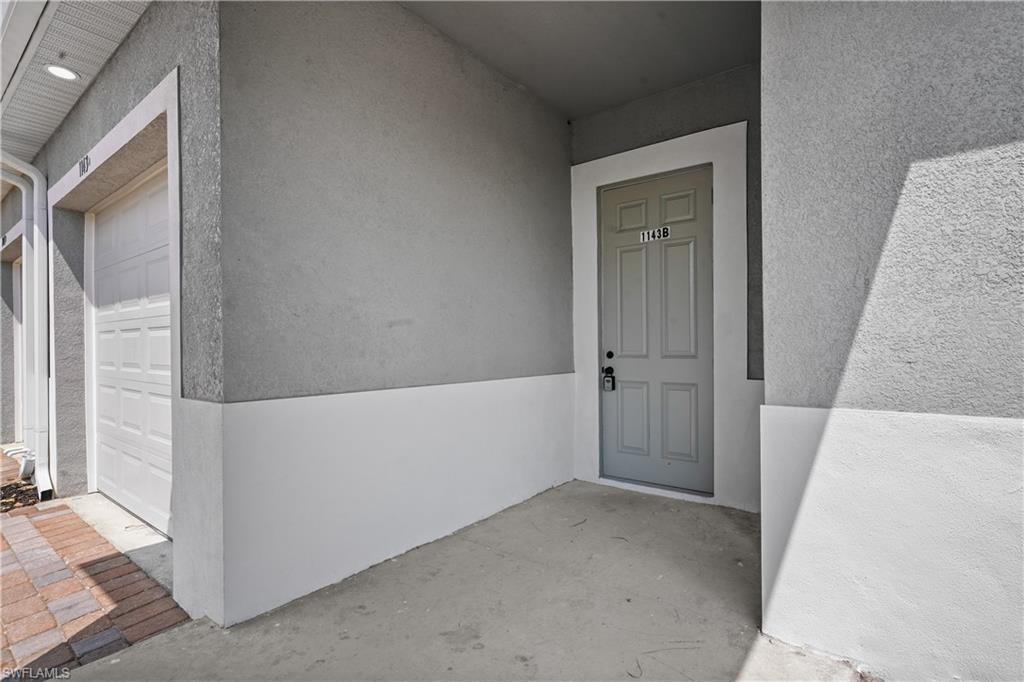 Doorway to property featuring a garage and stucco siding