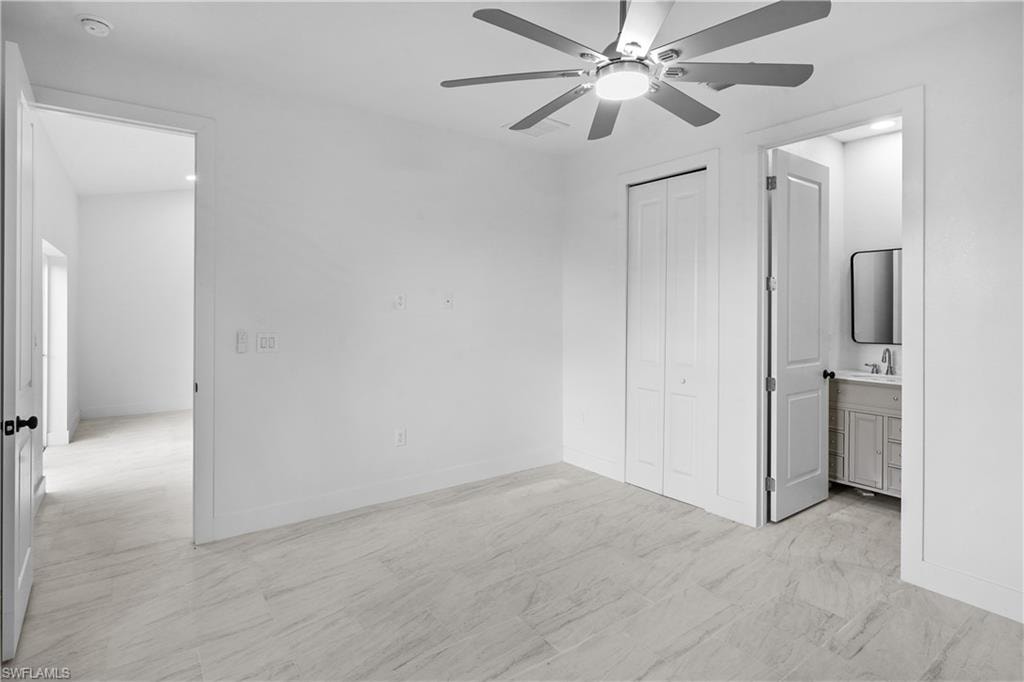 Unfurnished bedroom with ceiling fan, ensuite bathroom, and a closet