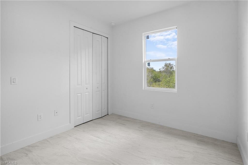 Unfurnished bedroom featuring a closet and baseboards
