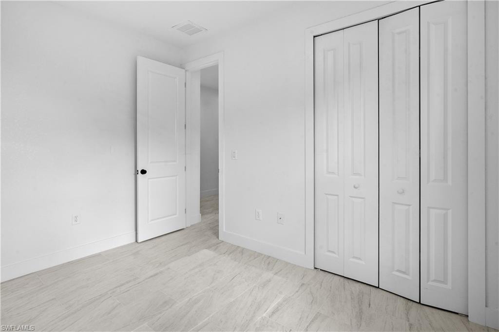 Unfurnished bedroom featuring baseboards and a closet
