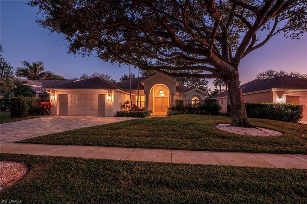 View of front of house featuring a garage and a yard