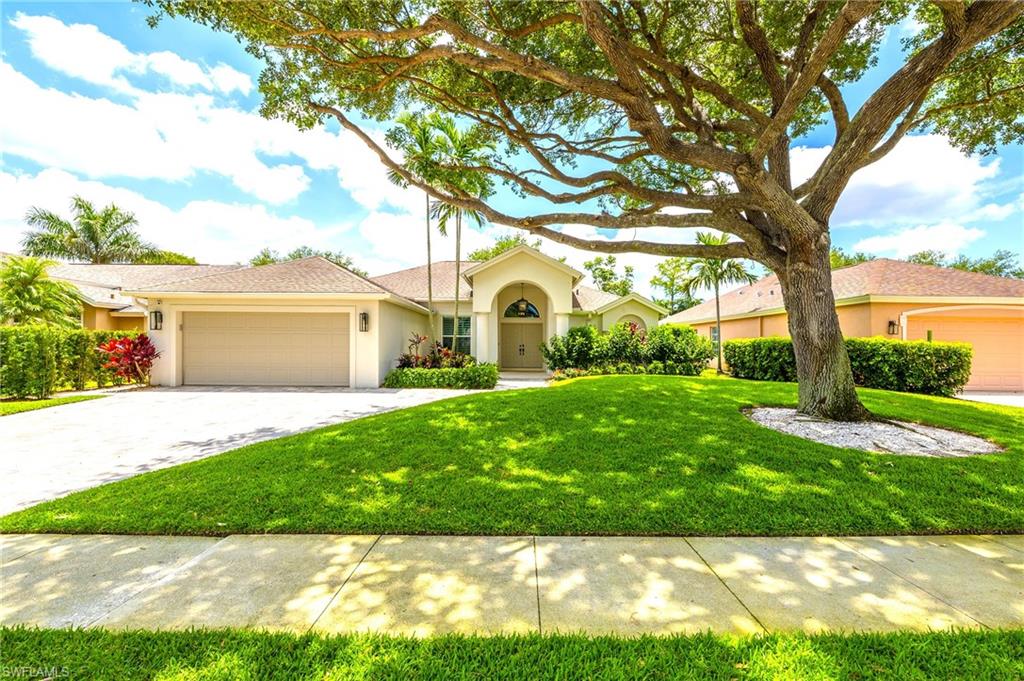 Ranch-style home featuring stucco siding, an attached garage, a front yard, and decorative driveway
