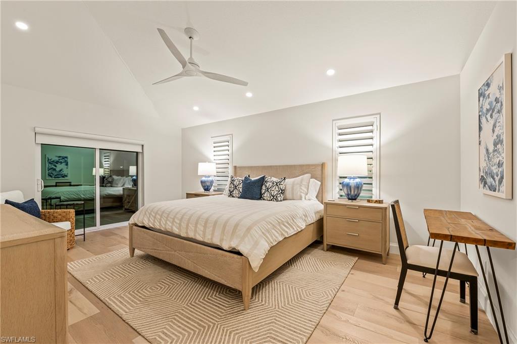Bedroom featuring light hardwood / wood-style flooring, access to exterior, vaulted ceiling, and ceiling fan