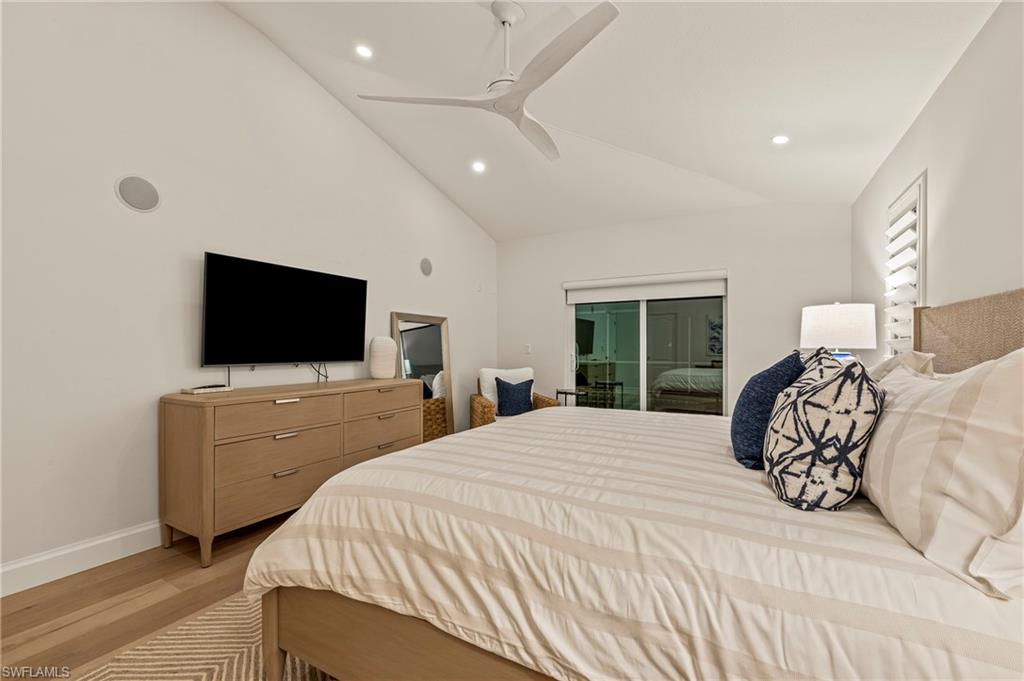 Bedroom with ceiling fan, lofted ceiling, and light wood-type flooring
