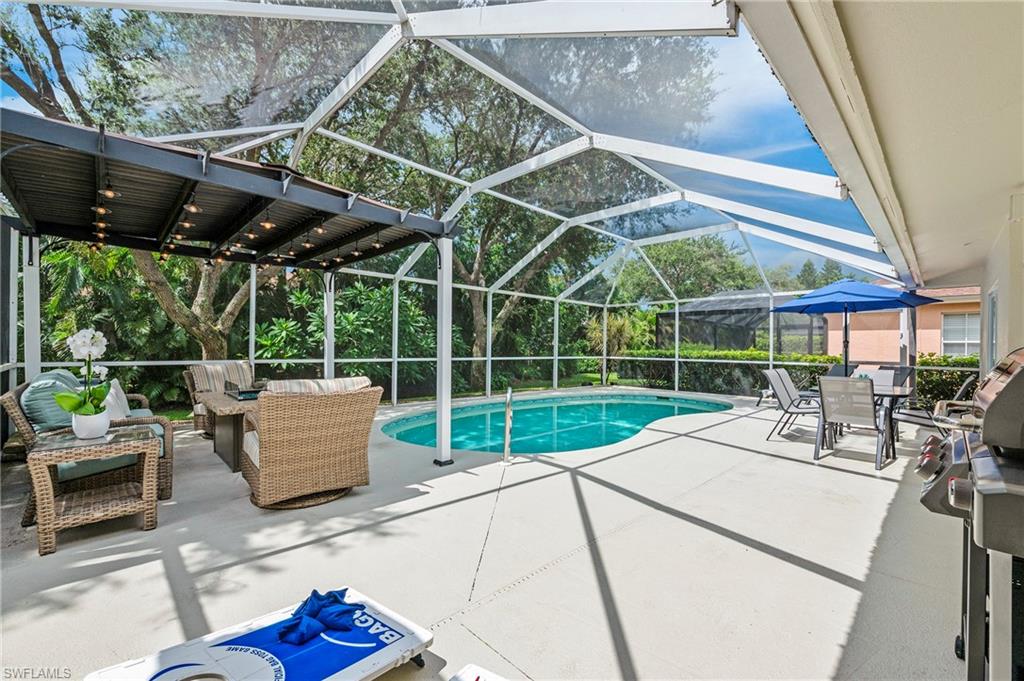 View of swimming pool with a patio, an outdoor hangout area, and glass enclosure
