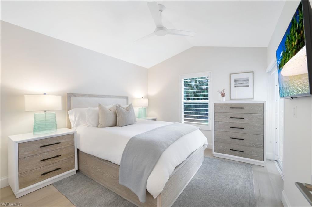 Bedroom featuring vaulted ceiling, light wood-type flooring, and ceiling fan