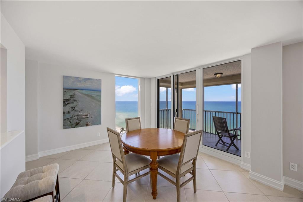 Dining room with plenty of natural light, light tile patterned flooring, expansive windows, and a water view
