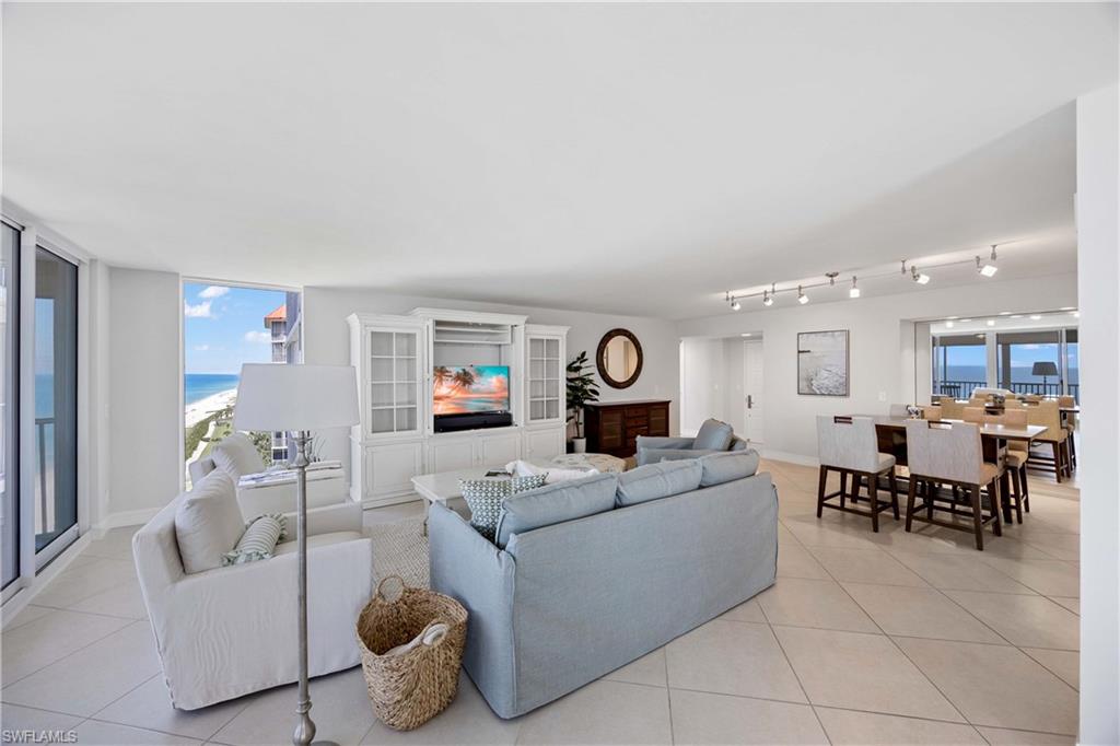 Living area with light tile patterned floors and floor to ceiling windows