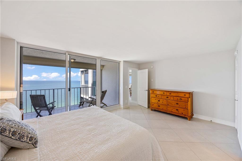 Bedroom featuring floor to ceiling windows, a water view, light tile patterned floors, and access to outside