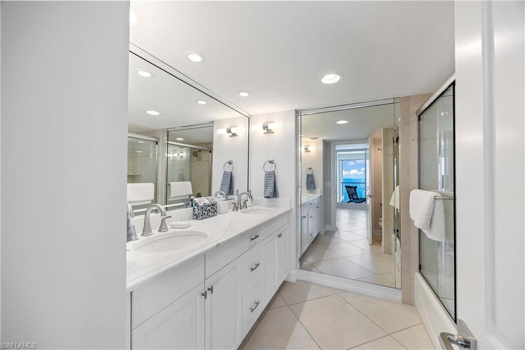 Ensuite bathroom with double vanity, light tile patterned floors, a stall shower, and recessed lighting