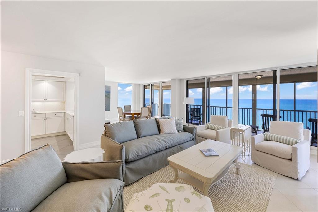 Tiled living area featuring floor to ceiling windows and a water view