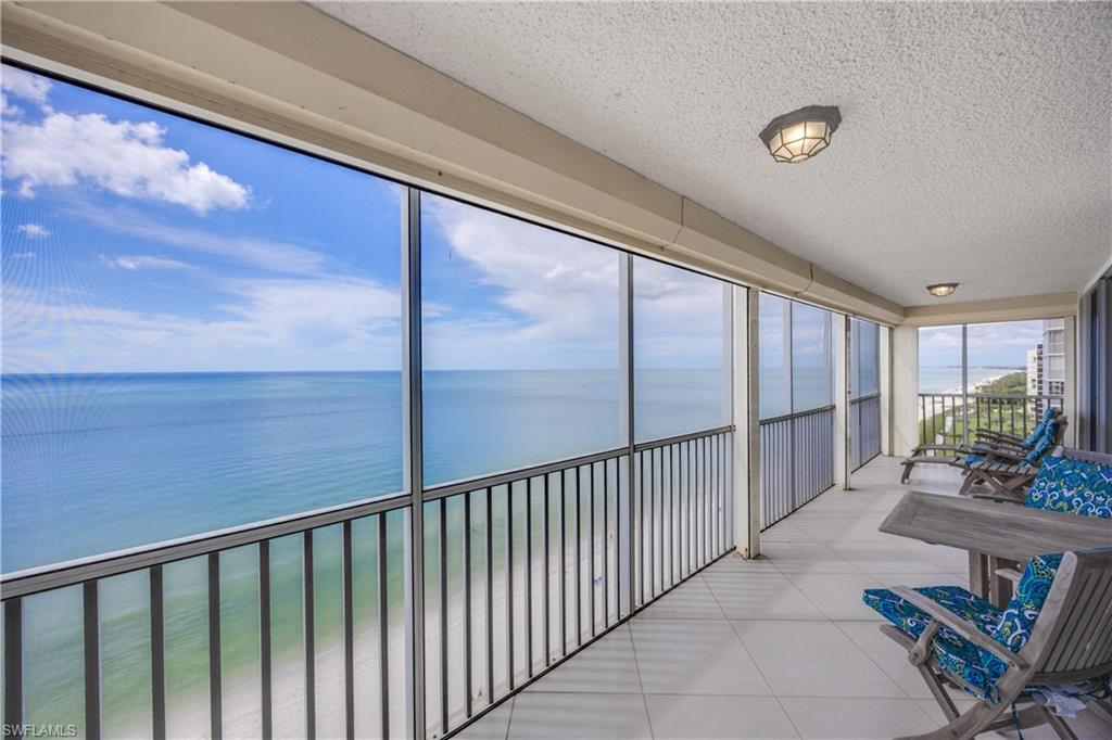Sunroom featuring a textured ceiling, a water view, and tile patterned flooring
