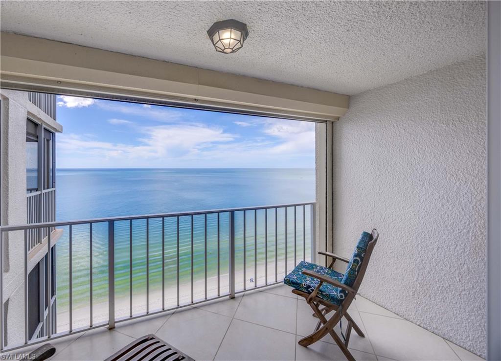 Balcony featuring view of water and beach
