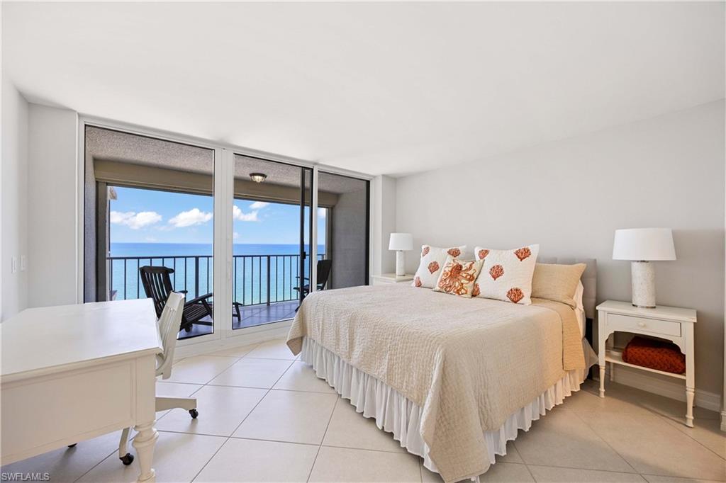 Bedroom with floor to ceiling windows, access to exterior, tile patterned floors, and a water view
