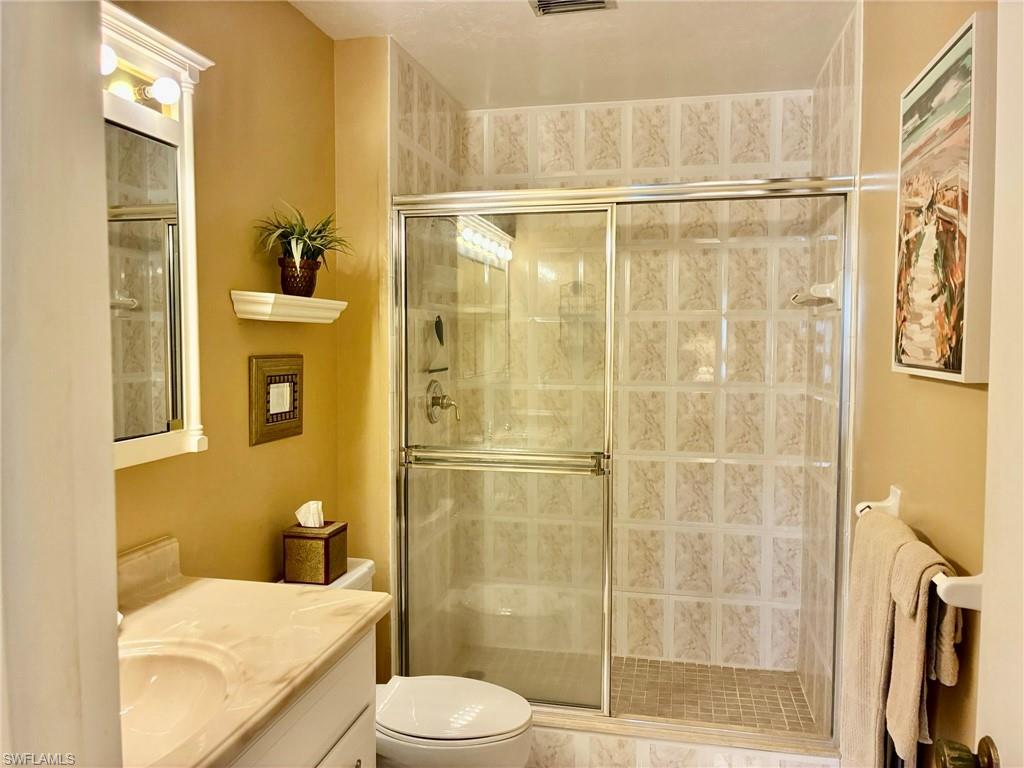 Full bath featuring a shower stall and vanity