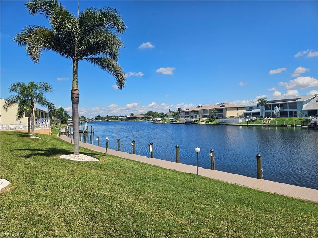 Dock area with a lawn, a water view, and a residential view
