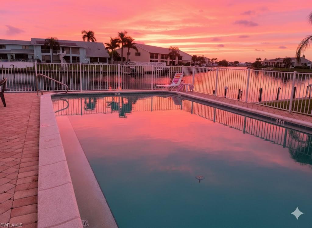 Community pool featuring a water view and a residential view