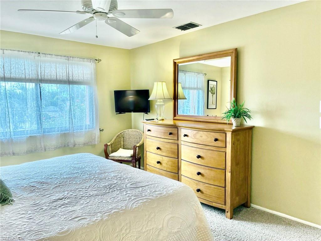 Bedroom with light colored carpet and ceiling fan