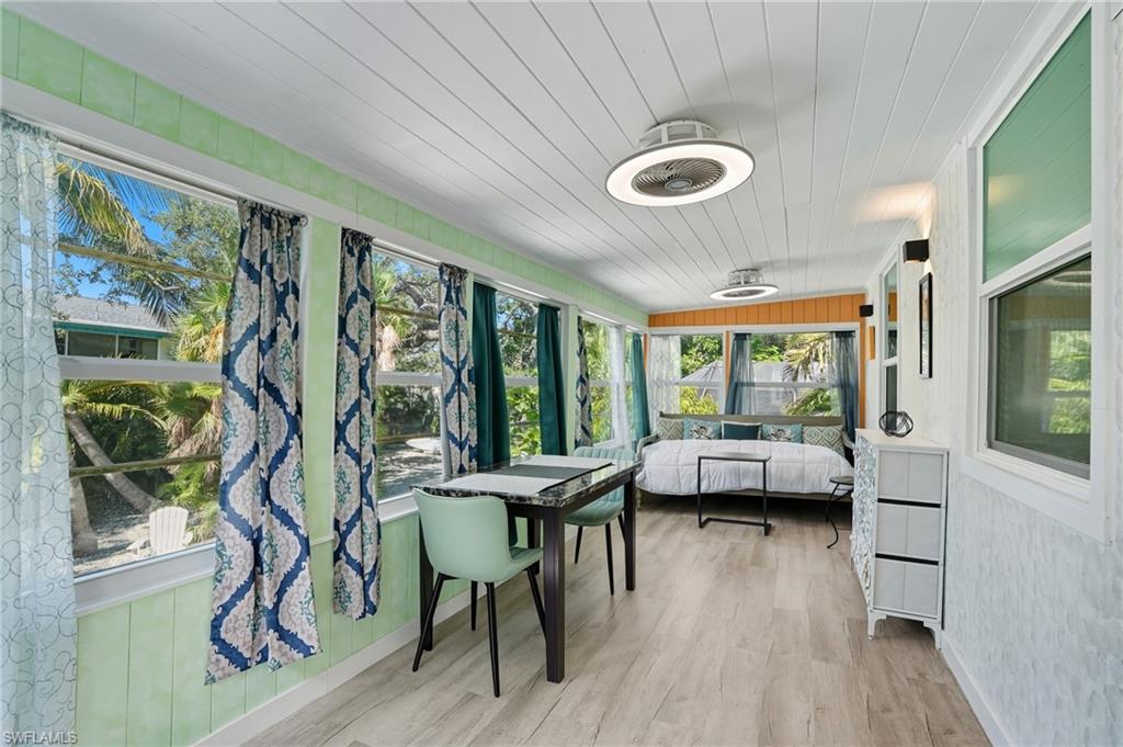 Sunroom with wood walls, wooden ceiling, and wood finished floors - Virtually Edited Image