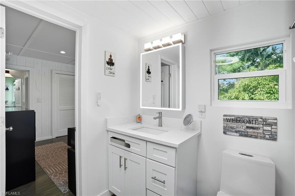 Bathroom featuring vanity, dark wood finished floors, and recessed lighting - Virtually Edited Image