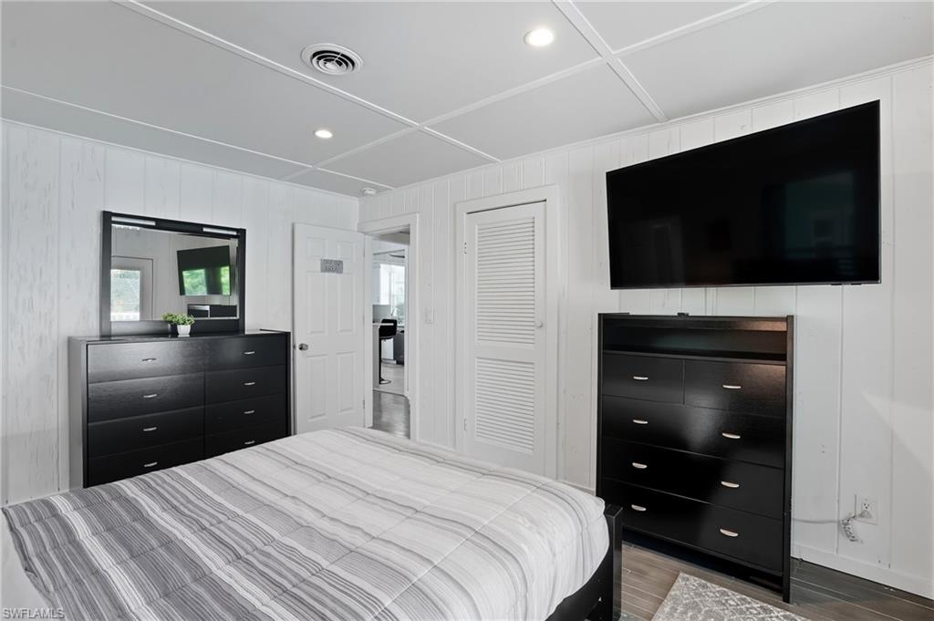 Bedroom with recessed lighting, wood finished floors, and a closet - Virtually Edited Image