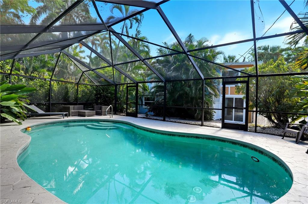 Swimming pool with a lanai, a sunroom, and a patio area - Virtually Edited Image