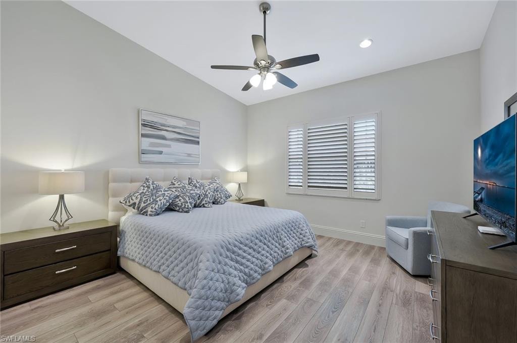 Bedroom with light wood-style floors, ceiling fan, vaulted ceiling, and recessed lighting