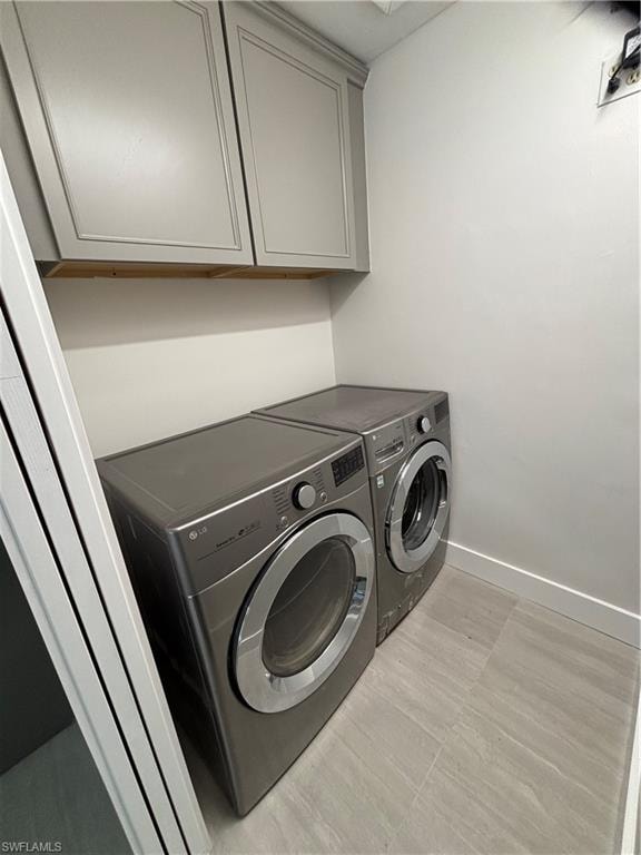 Laundry room with washer and clothes dryer and cabinet space