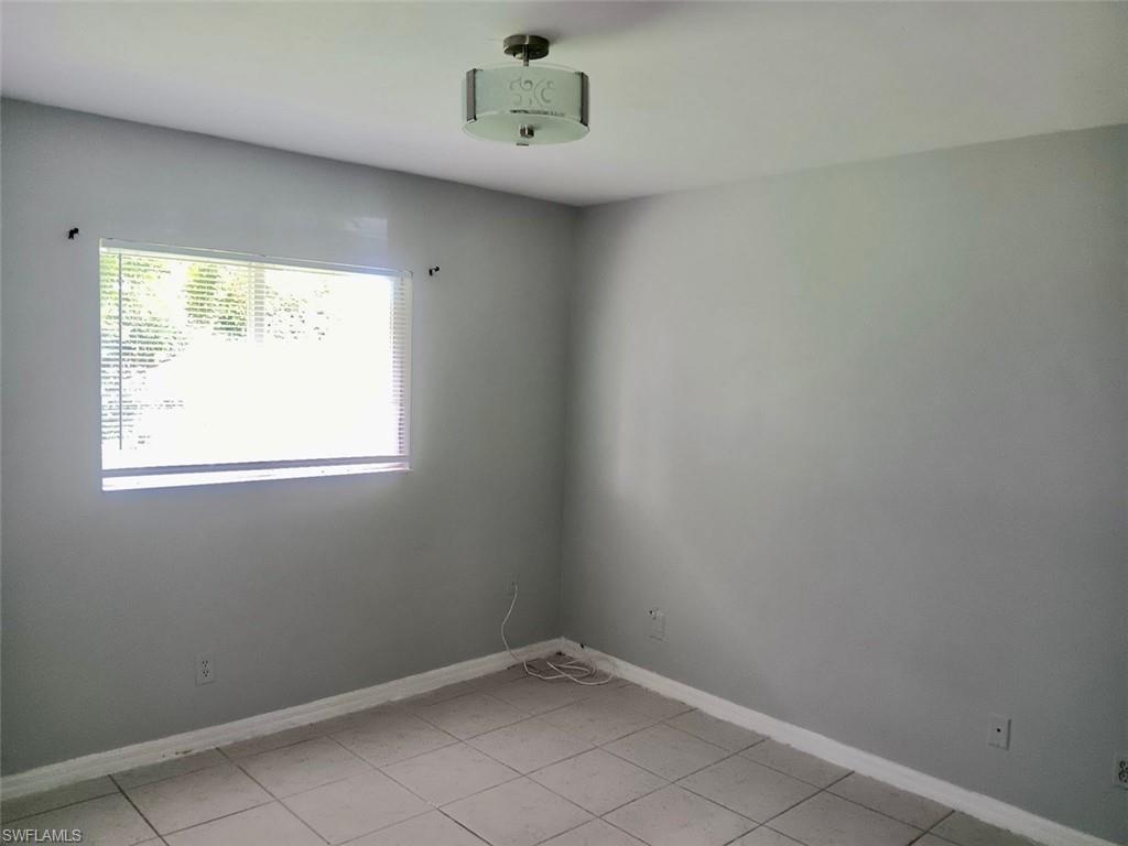 Unfurnished room featuring baseboards and light tile patterned flooring