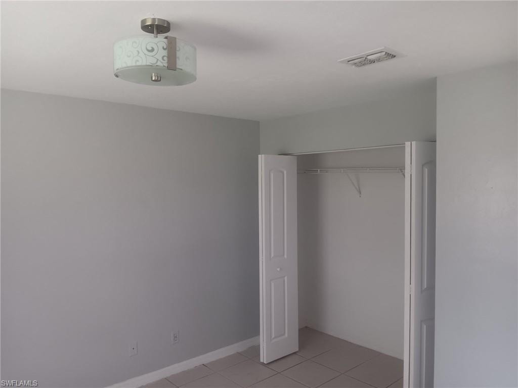 Unfurnished bedroom with light tile patterned floors and a closet