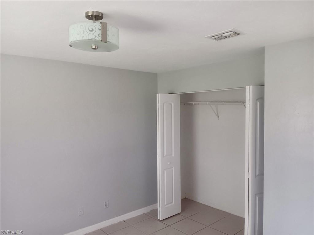 Unfurnished bedroom featuring light tile patterned floors and a closet