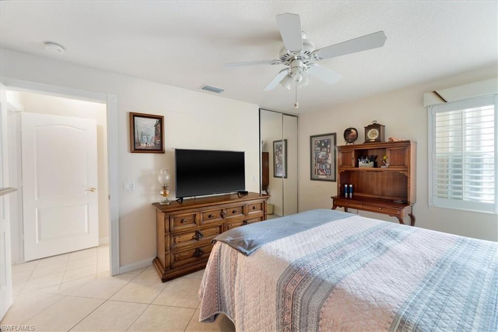 Bedroom featuring light tile patterned floors, a closet, and a ceiling fan