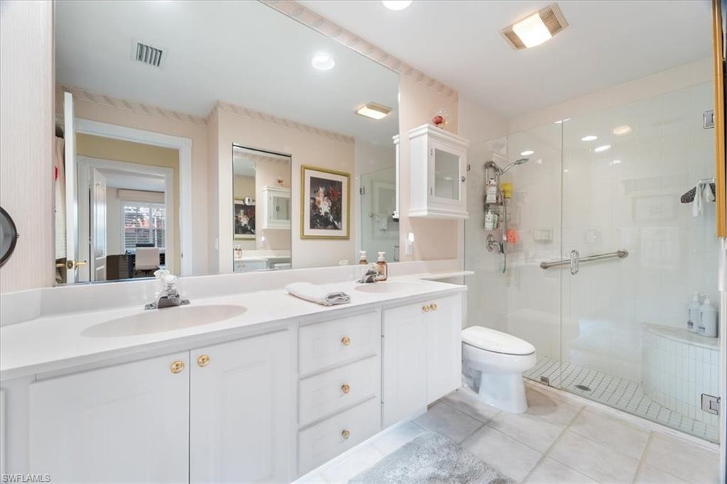 Full bathroom featuring a stall shower, double vanity, light tile patterned flooring, and recessed lighting