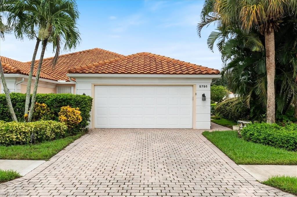 Mediterranean / spanish house with driveway, stucco siding, a tiled roof, and an attached garage