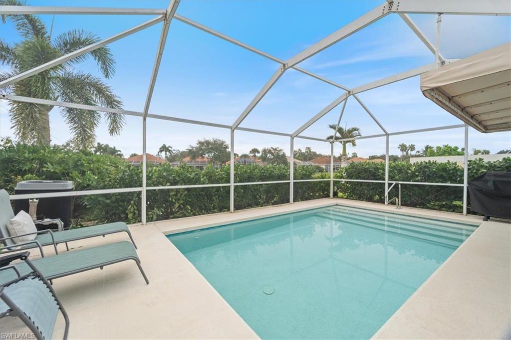 Swimming pool with a sunroom, grilling area, and a lanai