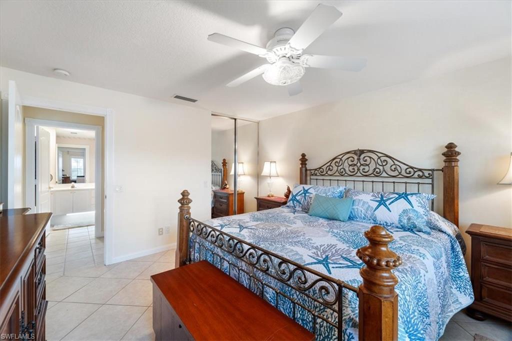 Bedroom featuring light tile patterned floors, a ceiling fan, and a closet