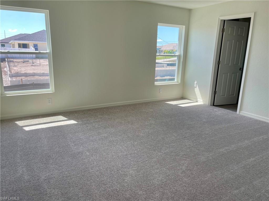 Carpeted empty room featuring baseboards