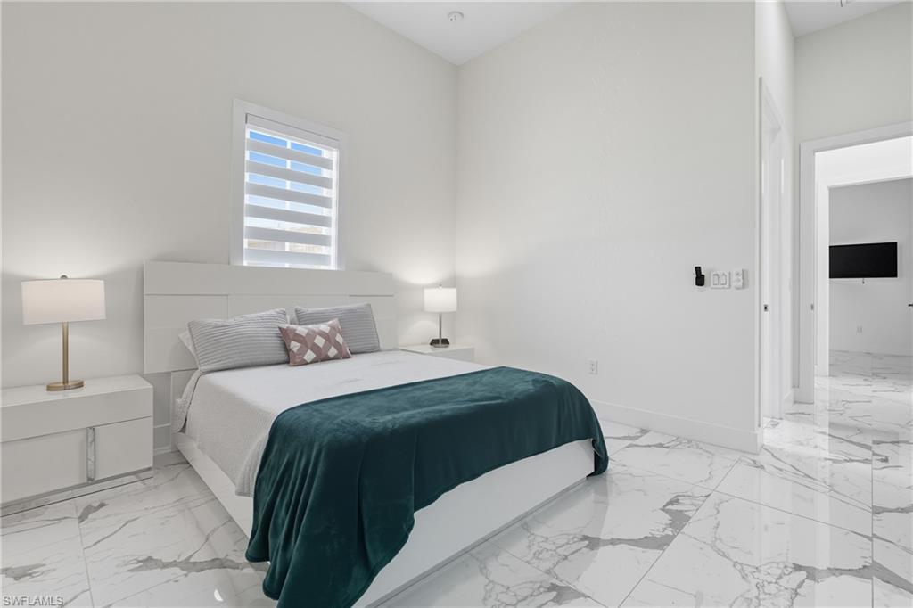 Bedroom with light marble finish floors and baseboards