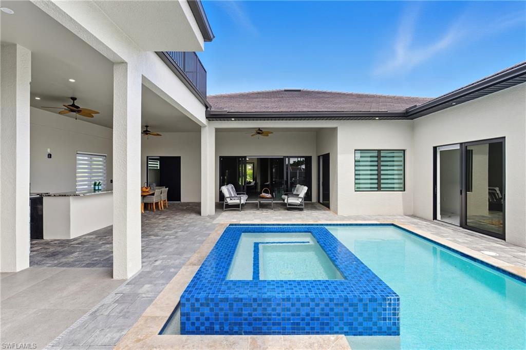 View of swimming pool with a patio, a pool with connected hot tub, and a ceiling fan